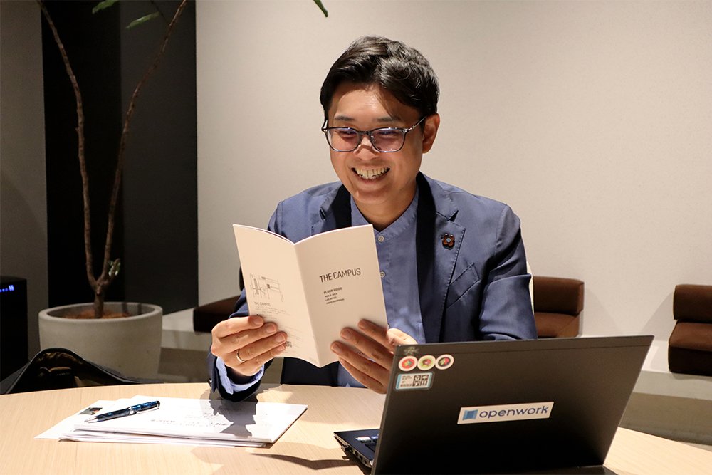コクヨ品川オフィスのオフィス「THE CAMPUS」の案内を手に取る大澤さん