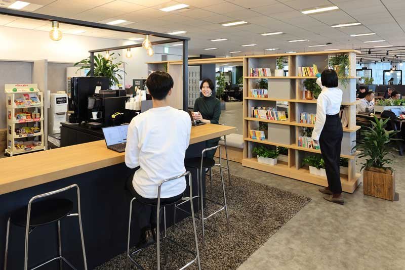 カフェカウンターで社員が談笑する様子